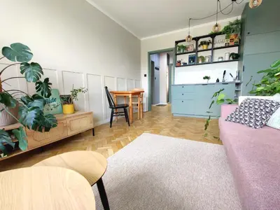a living room with a couch and a table with plants at Positive Vibes in Kraków