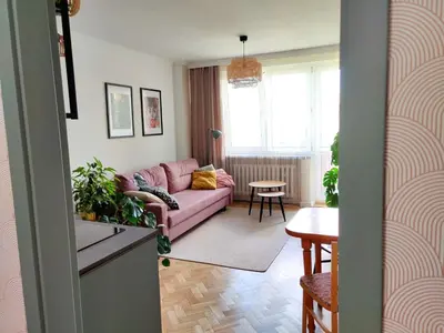 a living room with a pink couch and a table at Positive Vibes in Kraków