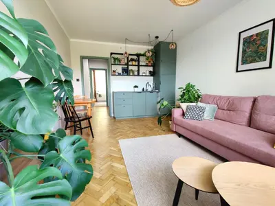 a living room with a pink couch and a table at Positive Vibes in Kraków