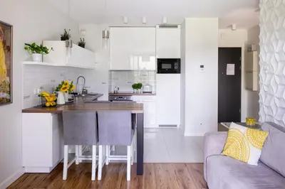 a kitchen with white cabinets and a kitchen island at Chick 1bdr loft in Krakow's city centre in Kraków