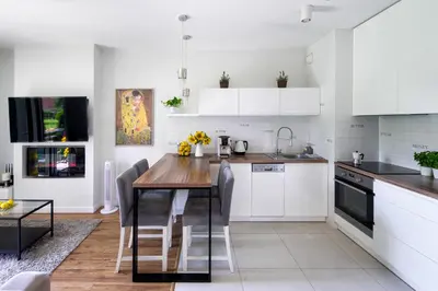 a kitchen with a wooden table and white cabinets at Chick 1bdr loft in Krakow's city centre in Kraków