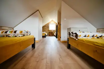a room with two beds in a attic at 3 Stodoły - domek 2 in Zator