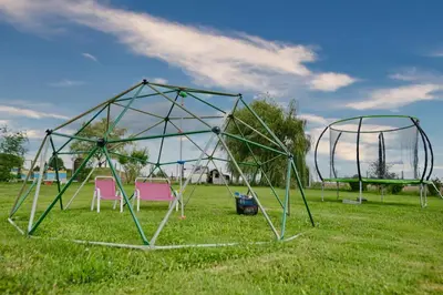 a swing set in a field with two chairs at 3 Stodoły - domek 2 in Zator