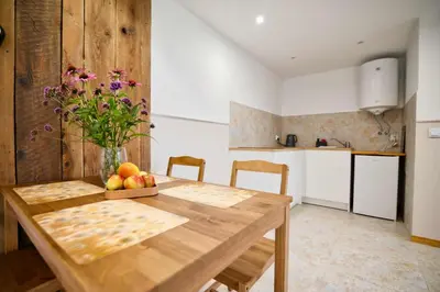 a kitchen with a wooden table with a bowl of fruit at 3 Stodoły - domek 2 in Zator