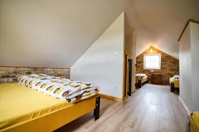a bedroom with a large bed in a attic at 3 Stodoły - domek 2 in Zator