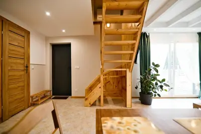 a room with a wooden staircase and a large window at 3 Stodoły - domek 2 in Zator