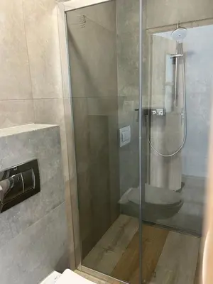 a shower with a glass door in a bathroom at Mieszkanie na Lawendowej in Kraków