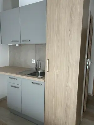 a kitchen with white cabinets and a sink at Mieszkanie na Lawendowej in Kraków