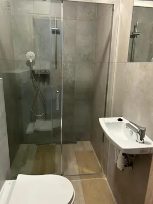 a bathroom with a shower and a toilet and a sink at Mieszkanie na Lawendowej in Kraków