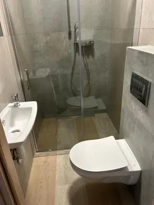 a bathroom with a shower and a toilet and a sink at Mieszkanie na Lawendowej in Kraków