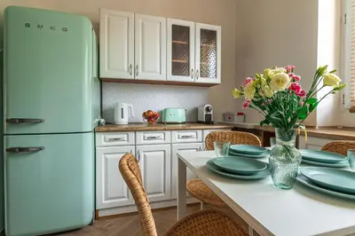 a kitchen with a table with plates and a refrigerator at Apartament HoliStay in Oświęcim