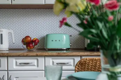 a kitchen counter with a bowl of apples and a toaster at Apartament HoliStay in Oświęcim