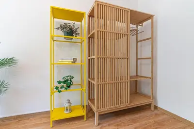 a yellow book shelf in a room at Apartament HoliStay in Oświęcim