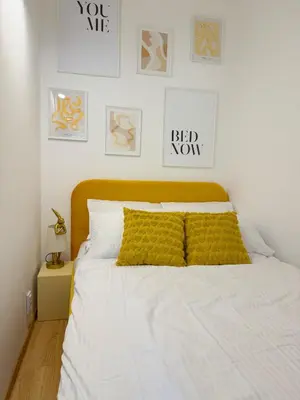 a bedroom with a bed with a yellow pillow on it at Apartament HoliStay in Oświęcim