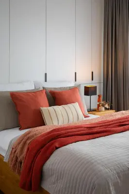 a bedroom with a large bed with red and white pillows at Apartamenty Lew Invest obok Rynku Głównego, Parking w cenie in Kraków