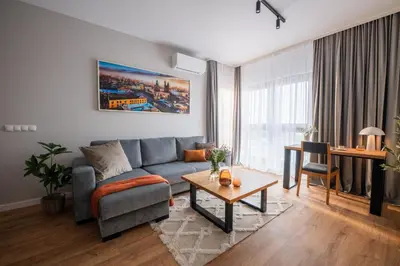 a living room with a blue couch and a table at Apartamenty Lew Invest obok Rynku Głównego, Parking w cenie in Kraków