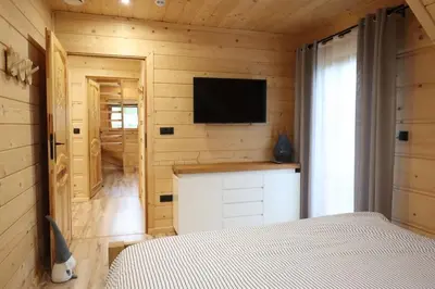 a bedroom with a bed and a television on a wall at Chata Gilowicka - Beskid Żywiecki in Gilowice