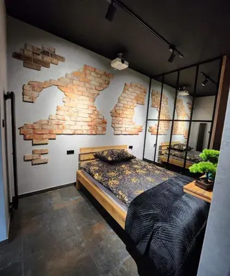 a bedroom with a large bed with a brick wall at Luxury River Side apartament, Free parking in Kraków