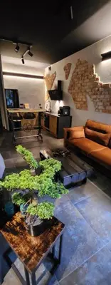 a living room with a couch and a table with plants at Luxury River Side apartament, Free parking in Kraków
