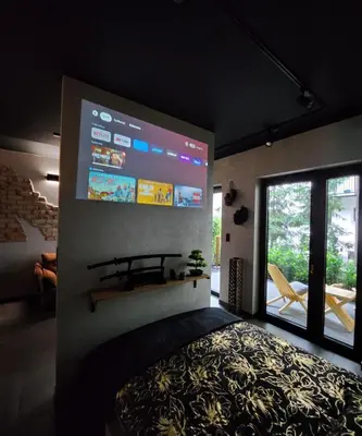 a living room with a large screen on the wall at Luxury River Side apartament, Free parking in Kraków