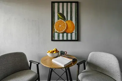 a table with a bowl of fruit and a picture of oranges at UR4N Apartment - Czarnogórska in Kraków