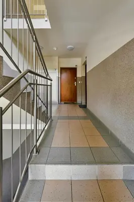 a hallway with stairs and a wooden door at UR4N Apartment - Czarnogórska in Kraków