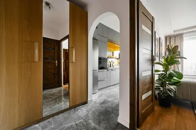 a kitchen with a hallway with a large mirror at UR4N Apartment - Czarnogórska in Kraków