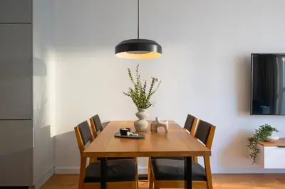 a dining room table with chairs and a vase on it at Apartamenty Lew Invest Wrocławska, Parking w cenie! in Kraków