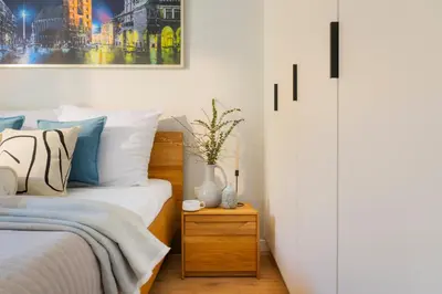 a bedroom with a bed and a vase on a night stand at Apartamenty Lew Invest Wrocławska, Parking w cenie! in Kraków