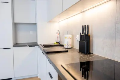 a kitchen with white cabinets and a counter top at Apartamenty Lew Invest Wrocławska, Parking w cenie! in Kraków