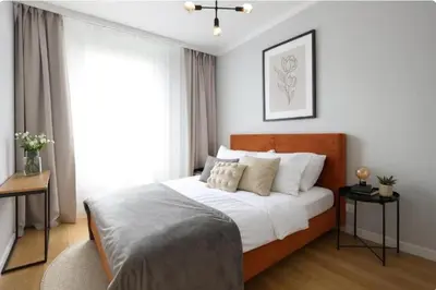 a bedroom with a bed with white sheets and pillows at Apartamenty Lew Invest Wrocławska, Parking w cenie! in Kraków