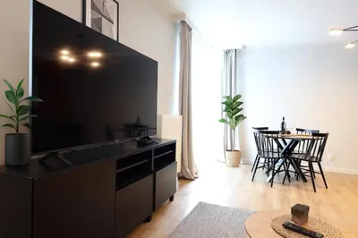 a living room with a large tv and a table at Apartamenty Lew Invest Wrocławska, Parking w cenie! in Kraków