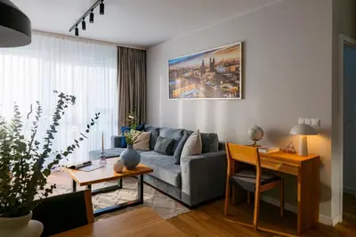 a living room with a couch and a table at Apartamenty Lew Invest Wrocławska, Parking w cenie! in Kraków