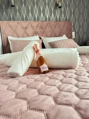 a bottle of beer sitting on top of a bed at Chill&Love Apartament