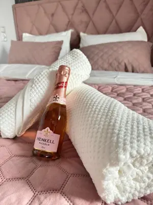 a bottle of beer sitting on a bed at Chill&Love Apartament