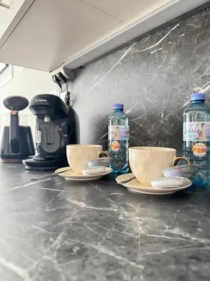 a counter with two cups and two bottles of water at Chill&Love Apartament
