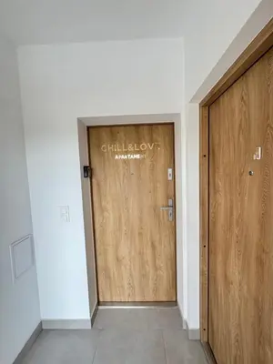 a hallway with two wooden doors in a building at Chill&Love Apartament