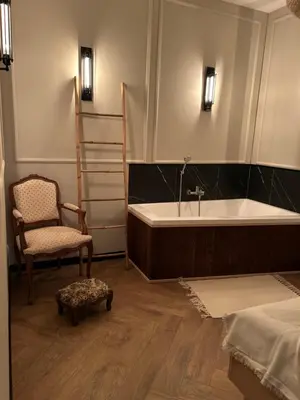a bathroom with a bath tub and a chair at La Ville - Jaune in Zator