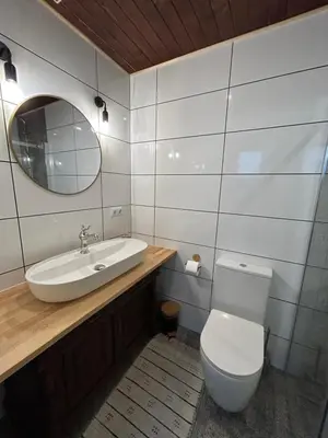 a bathroom with a toilet and a sink and a mirror at La Ville - Jaune in Zator