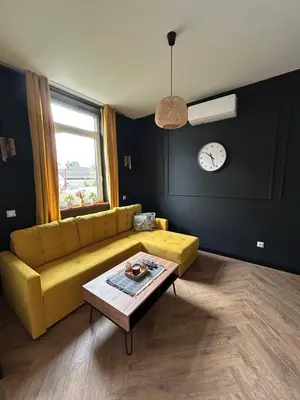 a living room with a yellow couch and a table at La Ville - Jaune in Zator