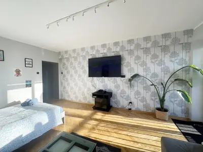 a bedroom with a bed and a living room at Fenna loft in Kraków
