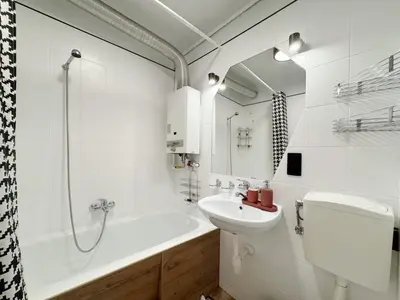 a bathroom with a sink and a toilet and a tub at Fenna loft in Kraków
