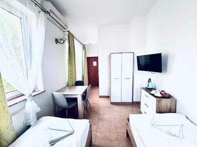a room with two beds and a desk and a tv at Gościniec i Restauracja Salton in Bochnia