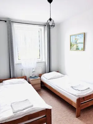 two twin beds in a room with a window at Gościniec i Restauracja Salton in Bochnia