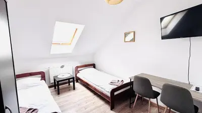 a small room with two beds and a table at Gościniec i Restauracja Salton in Bochnia