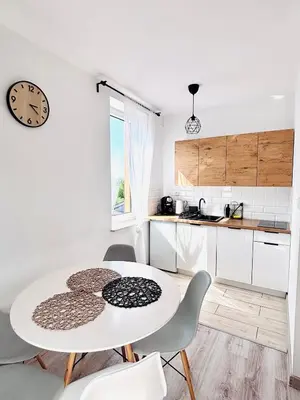 a kitchen with a table and chairs and a clock at Gościniec i Restauracja Salton in Bochnia