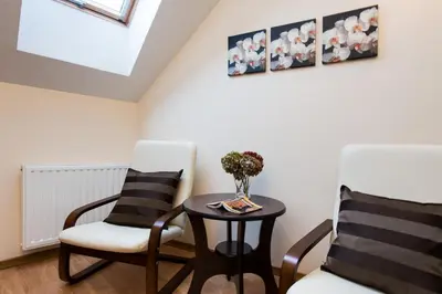 a room with two chairs and a table with a vase on it at Vanilla 1, 2bdr 2bth 5min to Main Square in Kraków