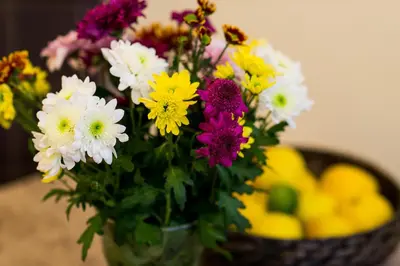 a vase filled with colorful flowers next to a basket of fruit at Vanilla 1, 2bdr 2bth 5min to Main Square in Kraków