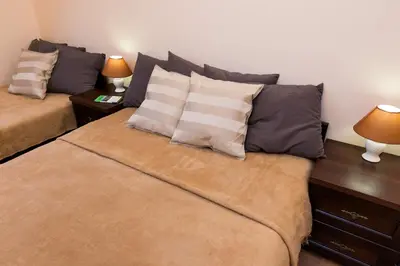 a bedroom with two beds with pillows and two lamps at Vanilla 1, 2bdr 2bth 5min to Main Square in Kraków