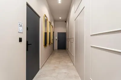 a hallway with white walls and a black door at LIFESTYLE Apartments in Bochnia